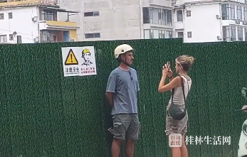 外国人在桂林旅游发现一处工地，于是戴上头盔和警示牌拍照打卡！网友：他们总能发现奇怪的景点