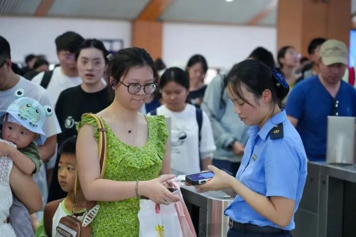 图为：8月17日上午，阳朔站客运员为旅客办理检票业务。（郑长贤 摄）.jpg