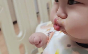 宝宝嘟嘴拒绝妈妈做的辅食，小手还紧握表示抗议。宝宝：不能哭 ，一哭一张嘴就是一勺