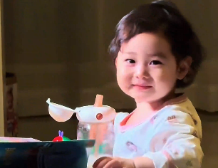 萌娃轉(zhuǎn)頭看到爸爸在拍自己，立馬滿(mǎn)眼笑意地起身跑向爸爸