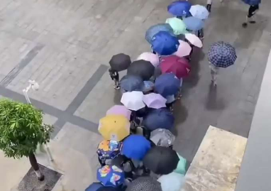 廣西突降暴雨，學(xué)生們用傘搭起“彩虹橋”