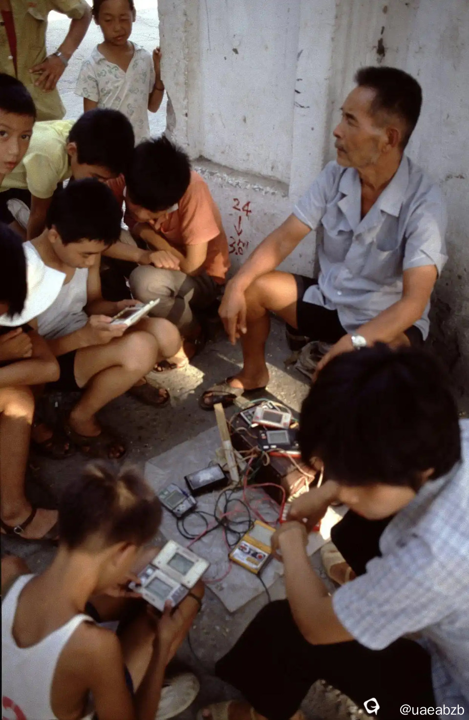 1985年的桂林，由外国摄影人Aad van der Drift拍摄，在路旁有一个奇怪的摊位，摊主坐在中间，旁边很多孩子 ...